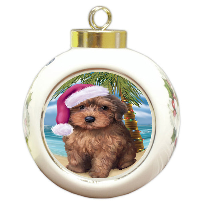 Summertime Happy Holidays Christmas Yorkipoo Dog on Tropical Island Beach Round Ball Christmas Ornament RBPOR54604