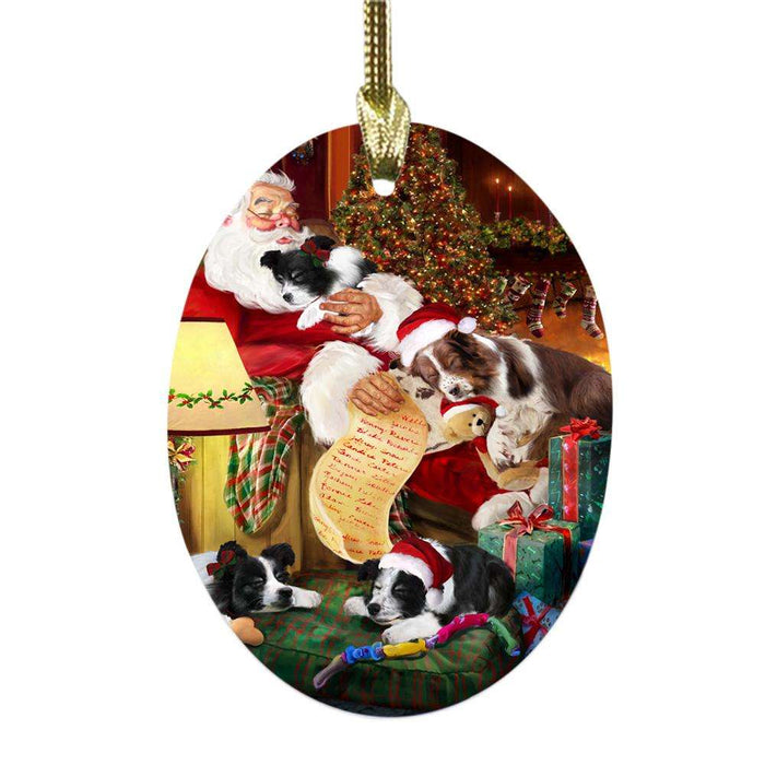 Border Collies Dog and Puppies Sleeping with Santa Oval Glass Christmas Ornament OGOR49255