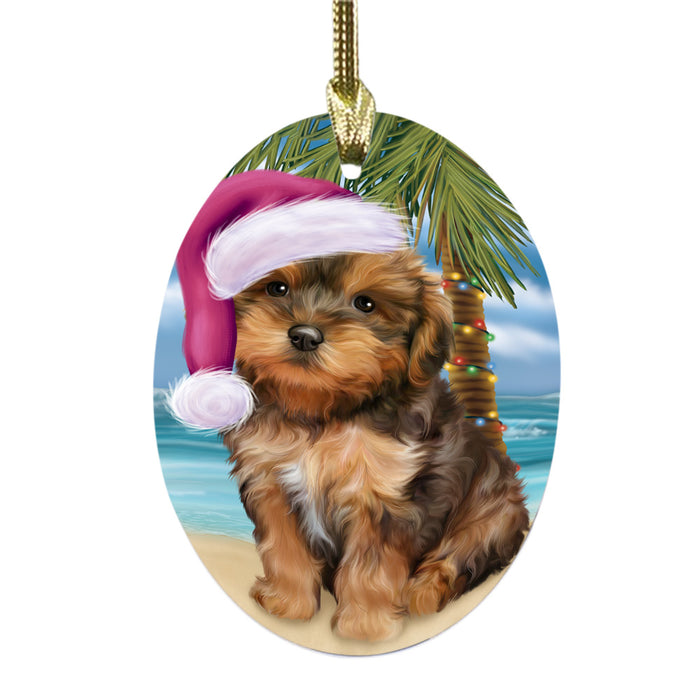 Summertime Happy Holidays Christmas Yorkipoo Dog on Tropical Island Beach Oval Glass Christmas Ornament OGOR49414