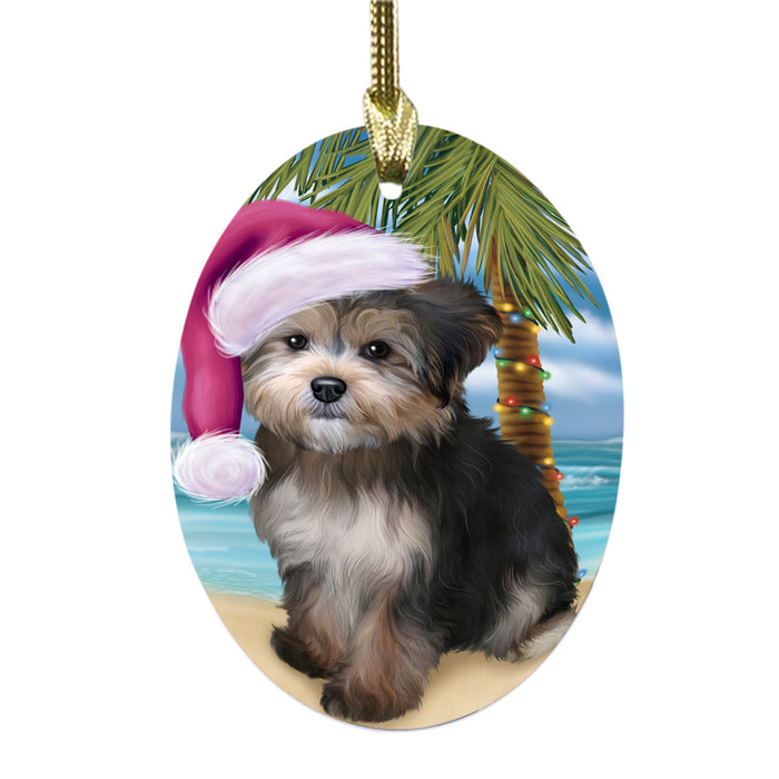 Summertime Happy Holidays Christmas Yorkipoo Dog on Tropical Island Beach Oval Glass Christmas Ornament OGOR49416