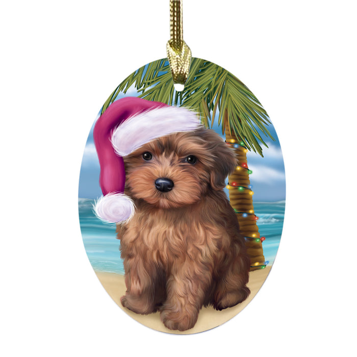 Summertime Happy Holidays Christmas Yorkipoo Dog on Tropical Island Beach Oval Glass Christmas Ornament OGOR49417